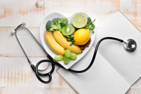 Plate with healthy products, stethoscope and notebook on tableの写真素材