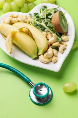 Plate with healthy products and stethoscope on color backgroundの写真素材