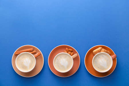 Cups of tasty cappuccino on color backgroundの写真素材