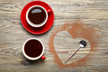 Cups of coffee with heart shape on wooden backgroundの写真素材