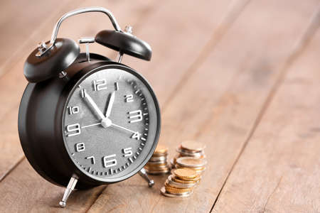 Alarm clock and money on table. Time management conceptの写真素材