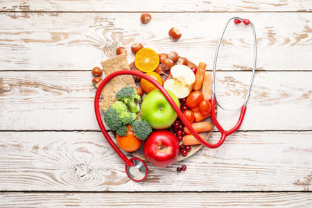 Plate with healthy products and stethoscope on white wooden backgroundの写真素材