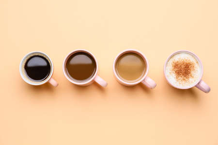 Cups of different coffee on color backgroundの写真素材