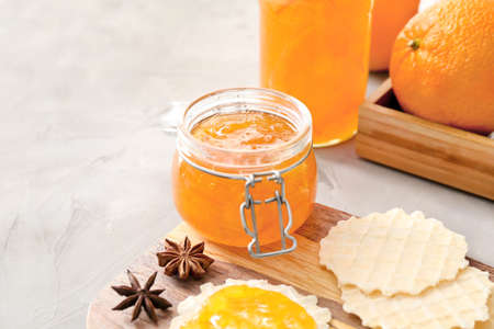 Jar of orange jam with wafers on tableの写真素材
