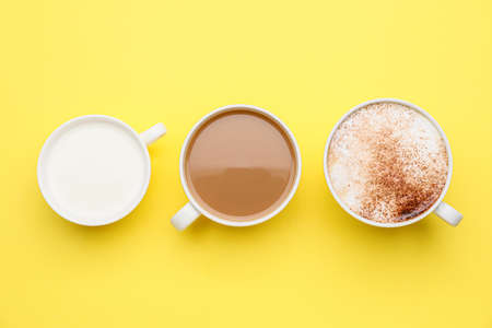 Cups of different coffee on color backgroundの写真素材