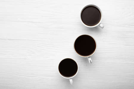 Cups of coffee on white wooden backgroundの写真素材