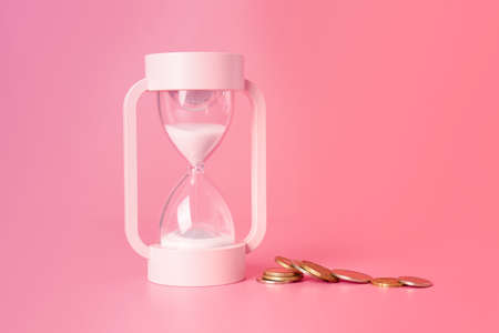 Hourglass and coins on color background. Time management conceptの写真素材