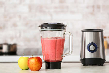 Blender with healthy smoothie on kitchen tableの写真素材