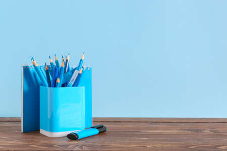 Holder with stationery on table against color backgroundの写真素材