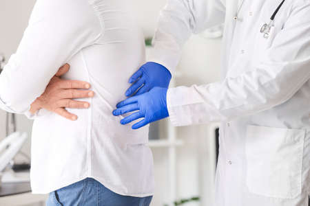 Urologist examining senior patient in clinic