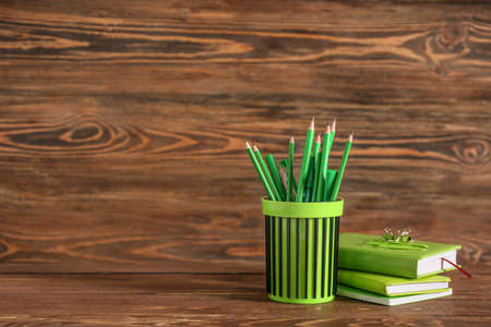 Holder with stationery on wooden backgroundの写真素材