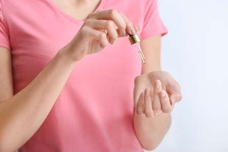 Woman applying essential oil on her hands, closeupの写真素材