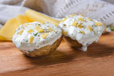 Tasty baked potato with sour cream on tableの写真素材