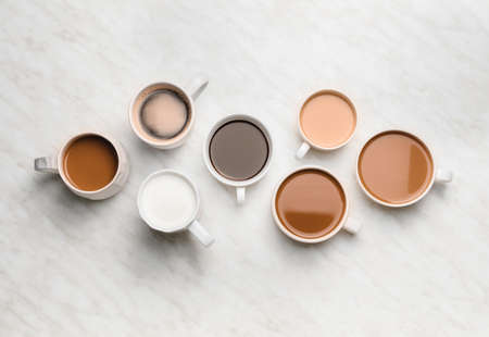 Cups of different coffee on light backgroundの写真素材