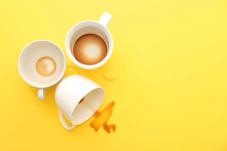 Empty cups and spilled coffee on color backgroundの写真素材