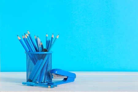 Holder with stationery on table against color backgroundの写真素材