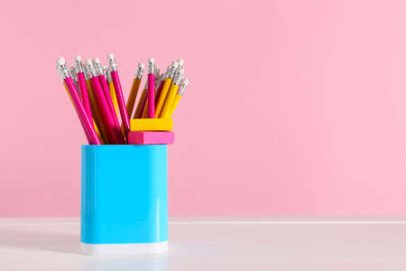 Holder with stationery on table against color backgroundの写真素材