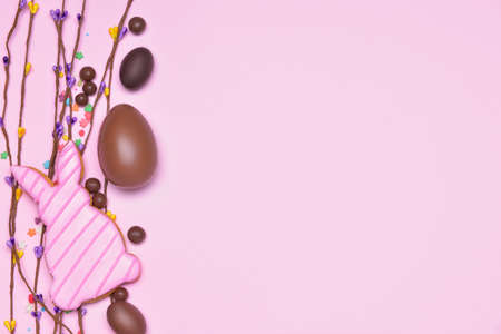 Composition with tasty chocolate Easter eggs and cookie on color backgroundの写真素材