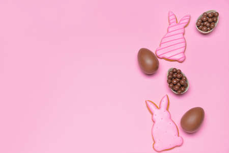 Tasty chocolate Easter eggs and cookies on color backgroundの写真素材
