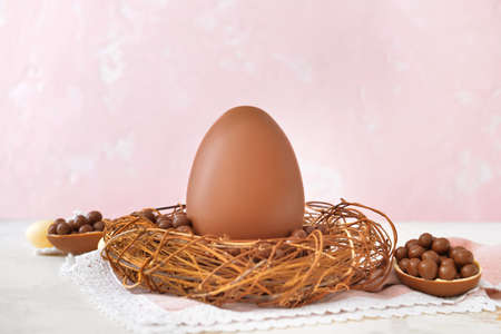 Nest with tasty chocolate Easter egg on tableの写真素材
