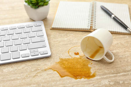 Overturned cup of coffee on office tableの写真素材
