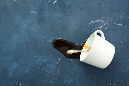 Overturned cup of coffee on dark backgroundの写真素材