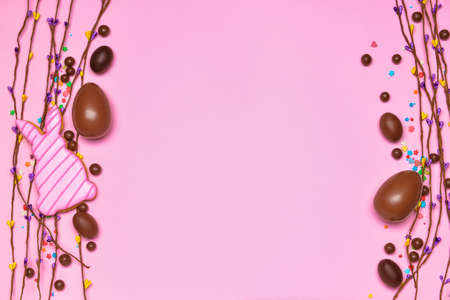 Composition with tasty chocolate Easter eggs and cookie on color backgroundの写真素材