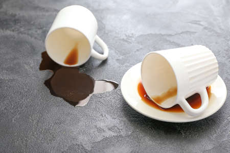 Overturned cups of coffee on gray backgroundの写真素材