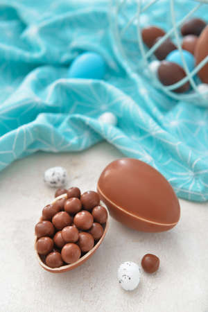 Tasty chocolate Easter eggs with candies on tableの写真素材