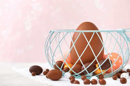 Basket with tasty chocolate Easter eggs on tableの写真素材