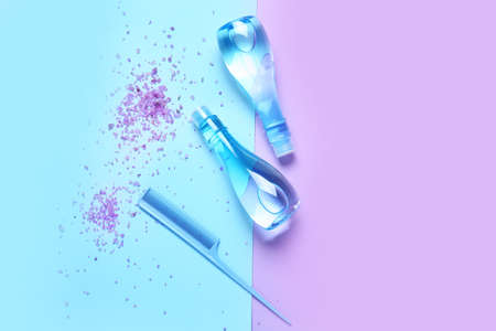 Shampoo, comb and sea salt on color backgroundの写真素材
