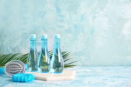 Shampoo, hair tie and brush on color backgroundの写真素材