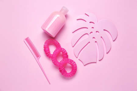 Composition with shampoo, hair ties and comb on color backgroundの写真素材