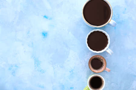 Cups of coffee on color background
