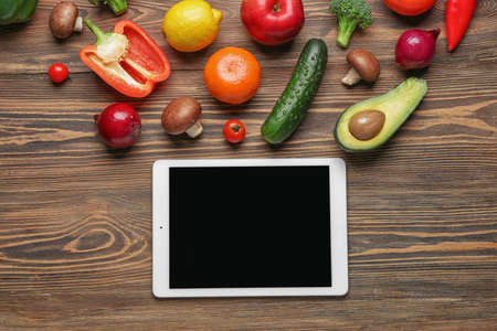 Tablet computer with healthy products on wooden backgroundの写真素材