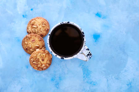 Cup of coffee with cookies on color backgroundの写真素材