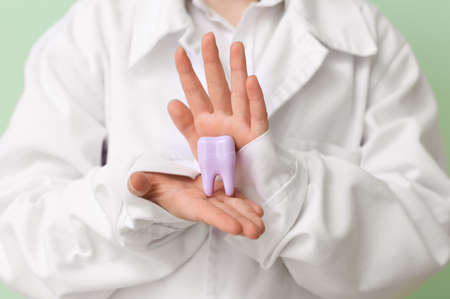 Little dentist with model of teeth on color background, closeupの写真素材