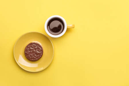 Cup of coffee with cookie on color backgroundの写真素材