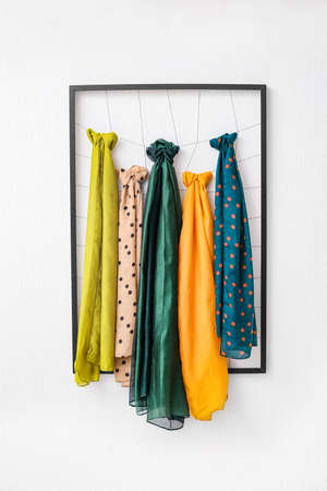 Frame with different beautiful scarves on white backgroundの写真素材