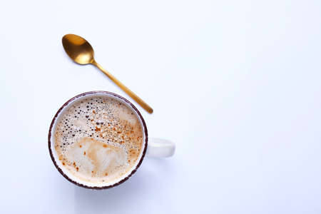 Cup of coffee with spoon on white backgroundの写真素材