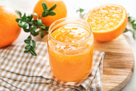 Jar of orange jam on table
