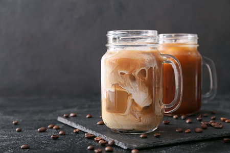 Mason jars of tasty iced coffee on dark backgroundの写真素材