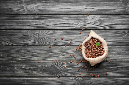 Bag with coffee beans on wooden backgroundの写真素材