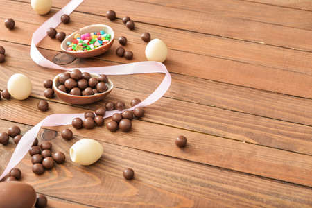 Chocolate eggs and candies on wooden tableの写真素材