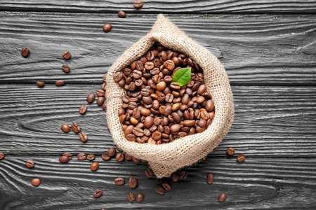 Bag with coffee beans on wooden backgroundの写真素材