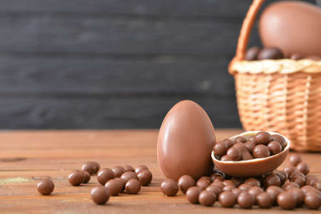 Chocolate eggs and candies on wooden tableの写真素材