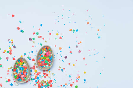 Chocolate eggs and sprinkles on white backgroundの写真素材