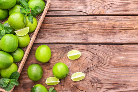 Tray with fresh limes on wooden backgroundの写真素材