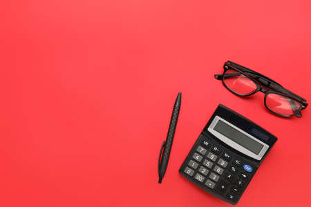 Calculator with pen and eyeglasses on color backgroundの写真素材