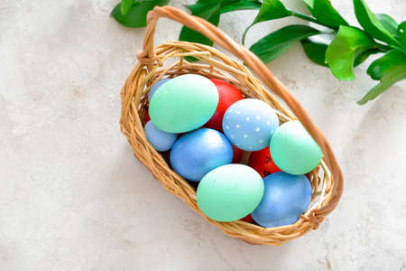 Basket with beautiful Easter eggs on white backgroundの写真素材